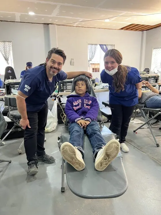 Dr. Godfrey and a volunteer with a young patient during a dental service trip