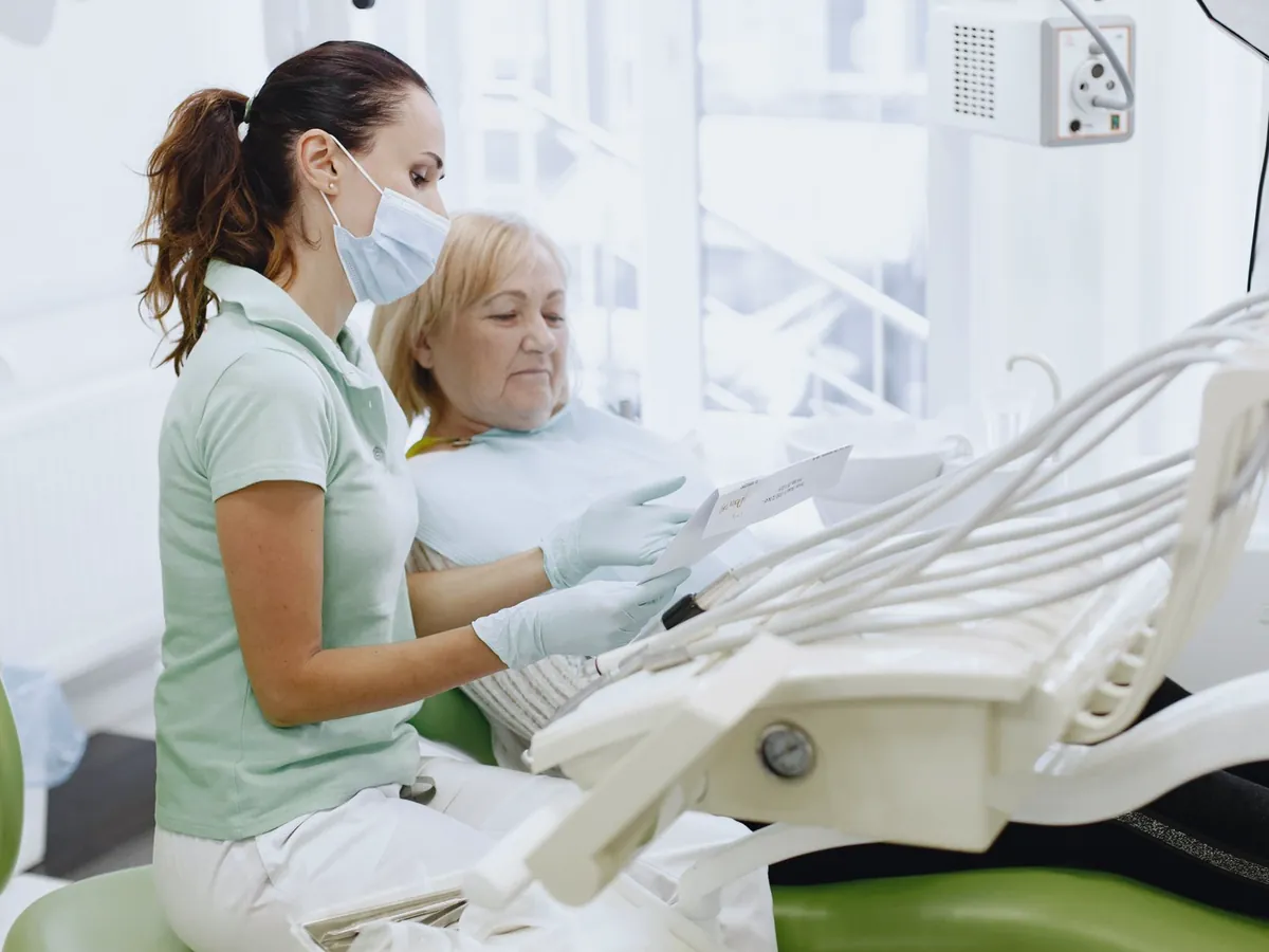 Hygienist talking with a patient in a dental chair